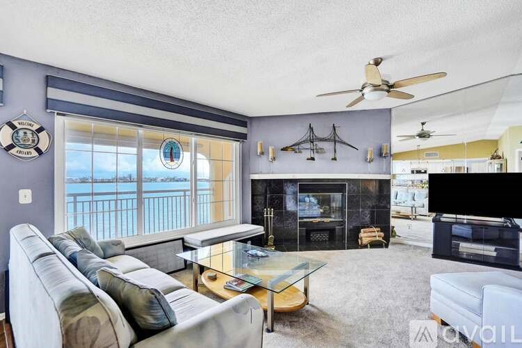 A living room with a grey couch and a fireplace.