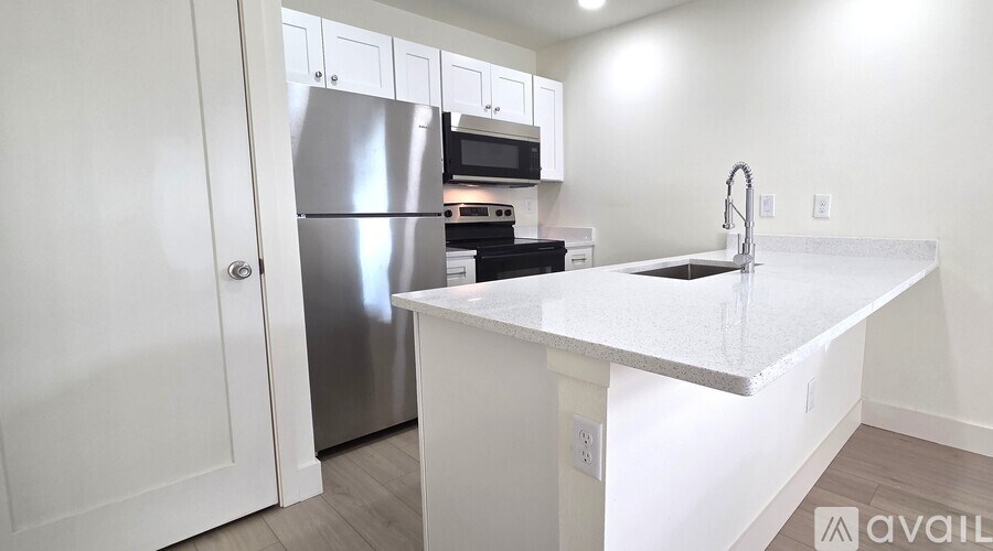 A kitchen with a white countertop and stainless steel appliances.