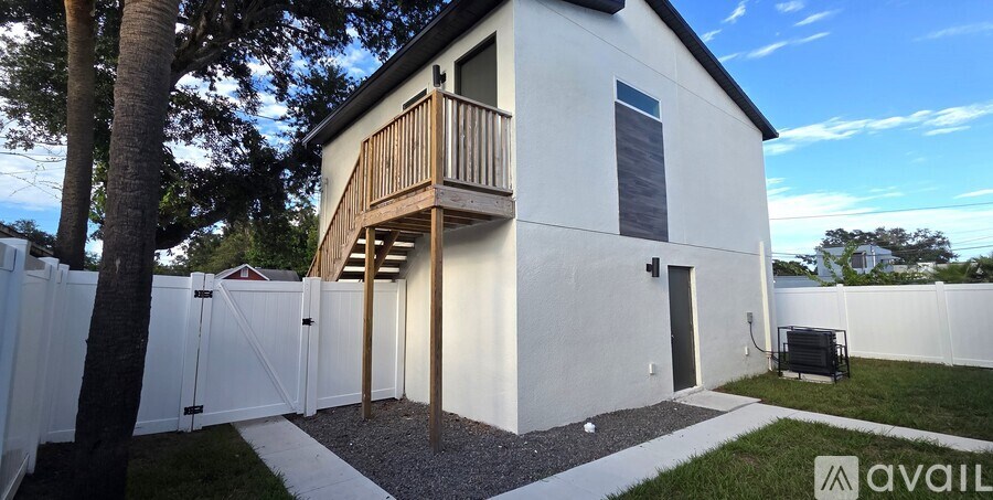 A house with a balcony and a white fence.