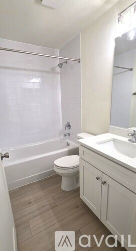 A bathroom with a toilet, sink, and bathtub.