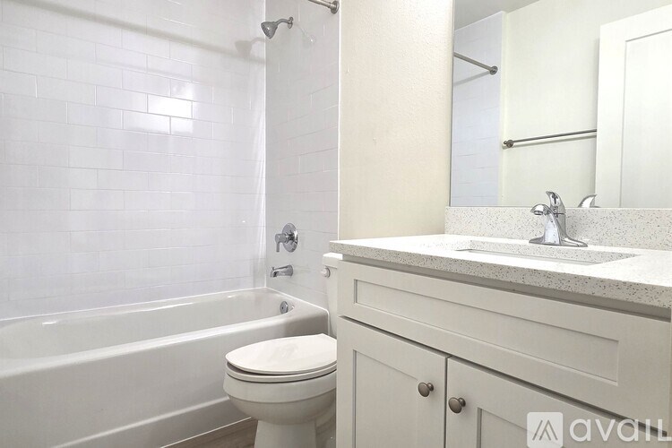A white bathroom with a toilet, sink, and bathtub.