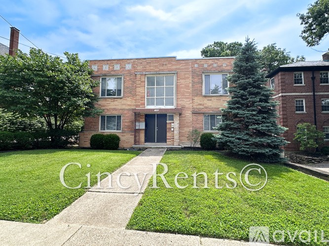 A brick building with a green lawn in front.