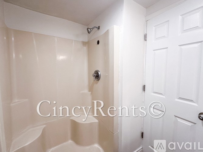 A white bathroom with a shower and a door.