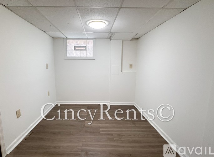 A room with a window and a wooden floor.