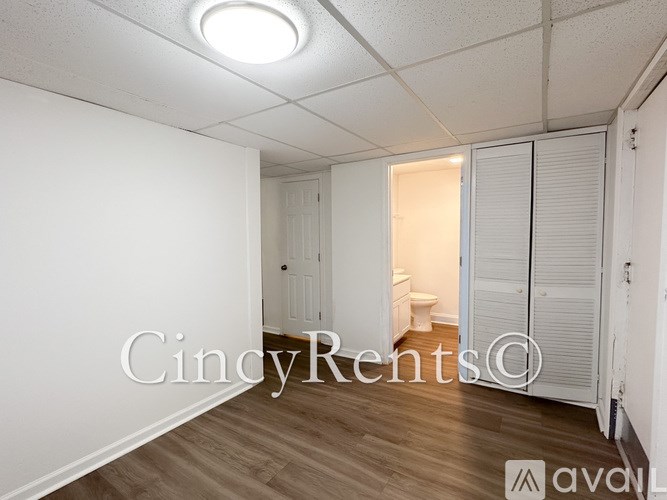 A room with a toilet and a cabinet in it.