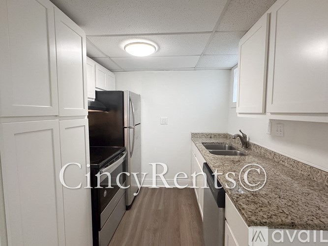A kitchen with white cabinets and a granite countertop.