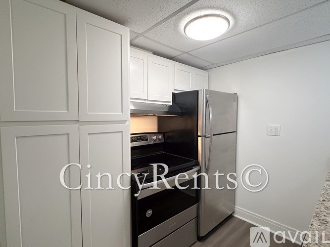 A kitchen with white cabinets and a stainless steel refrigerator.