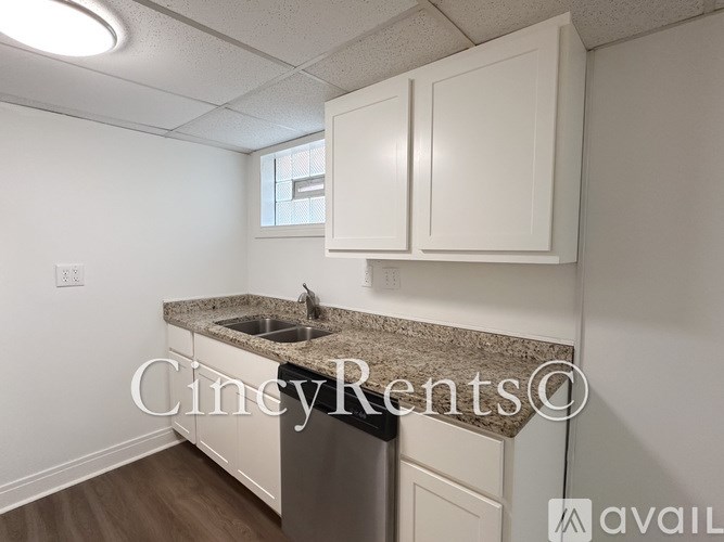A kitchen with white cabinets and a granite countertop.