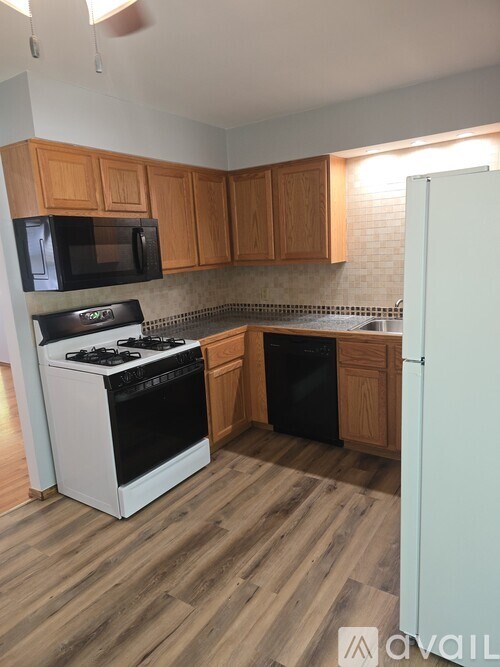 A kitchen with wooden cabinets and a white refrigerator.