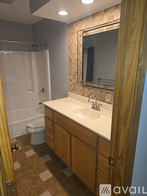 A bathroom with a white sink and a shower with a glass door.