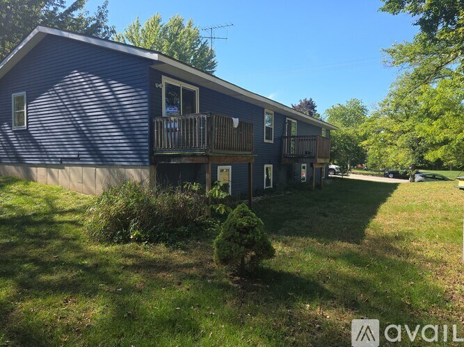 A blue house with a balcony and a small garden in front.