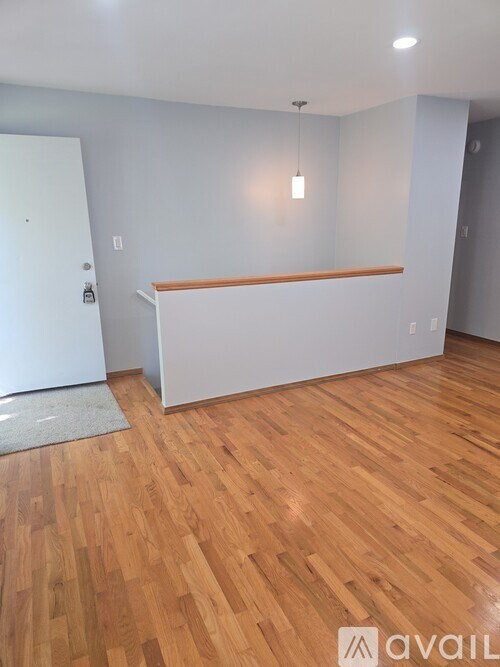 A room with wooden flooring and a white wall.