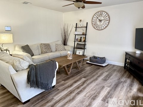 A living room with a white couch and a wooden coffee table.