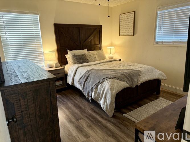 A bedroom with a large bed and a wooden dresser.
