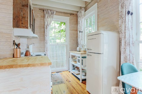 A kitchen with a white refrigerator and wooden cabinets.