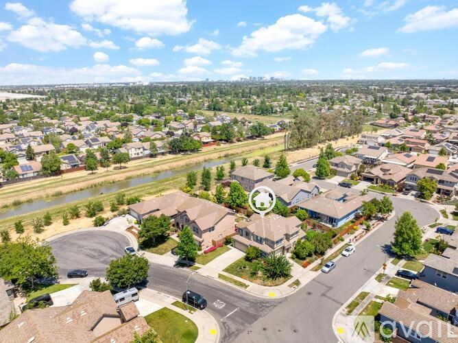 A bird's eye view of a residential area with houses, roads, and a river.