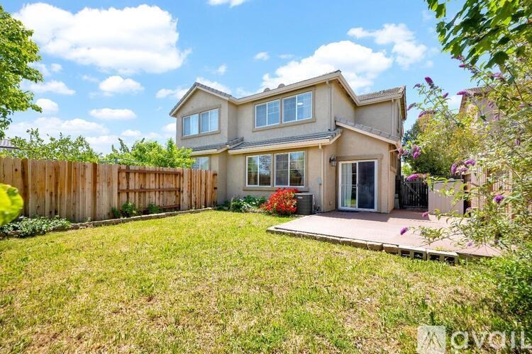 A house with a wooden fence and a green lawn.