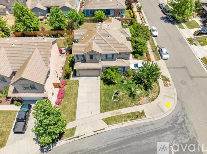 A suburban neighborhood with houses and parked cars.