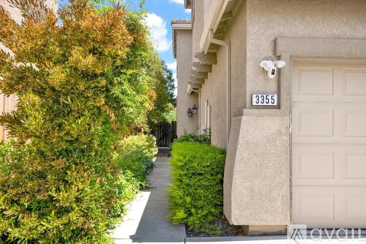 A house numbered 3355 is shown with a garage door and a tree.