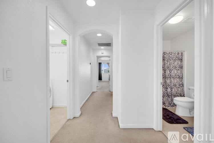 A hallway with white walls and a carpeted floor.