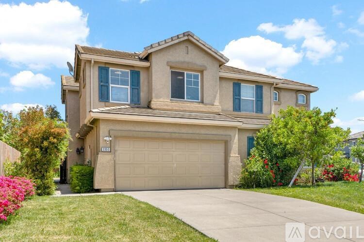 A house with a garage and a driveway in front of it.