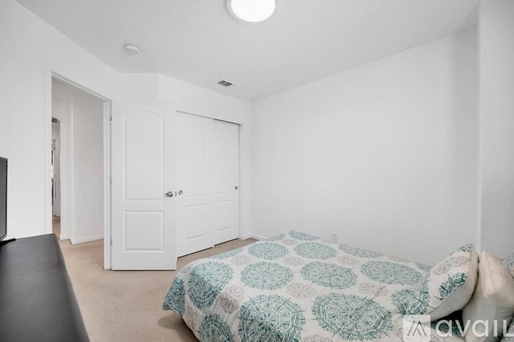 A bedroom with a bed and a black couch.