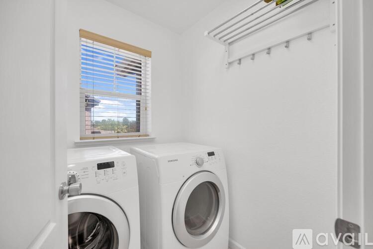 Two white front loading washing machines in a laundry room.