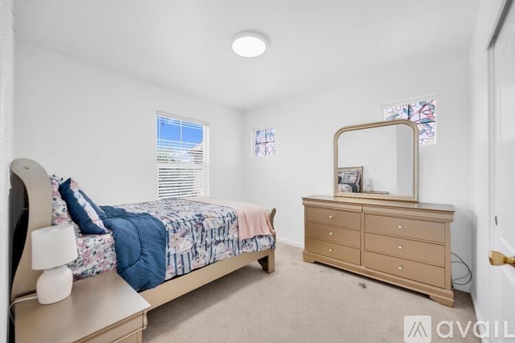 A bedroom with a bed, dresser, and mirror.
