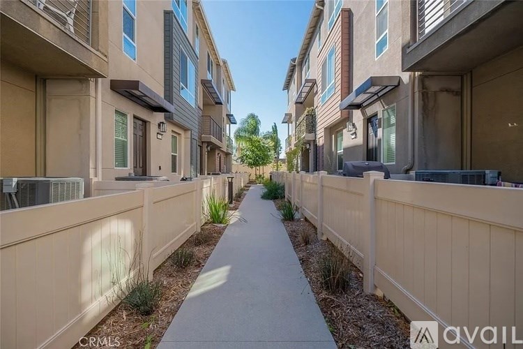 A row of modern apartment buildings with a sidewalk in the foreground.