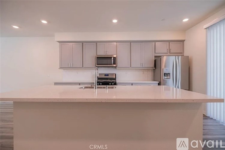 A kitchen with a white countertop and cabinets.