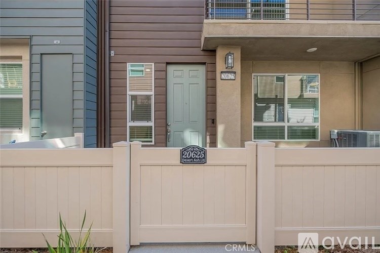 A modern house with a white fence and a sign that reads "26625".