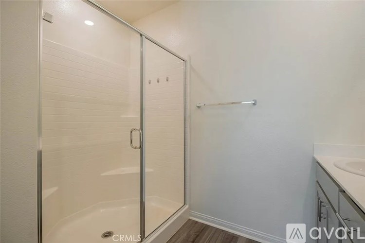 A bathroom with a glass shower door and a white bathtub.