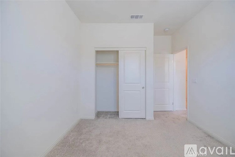 A room with a white door and carpeted floor.