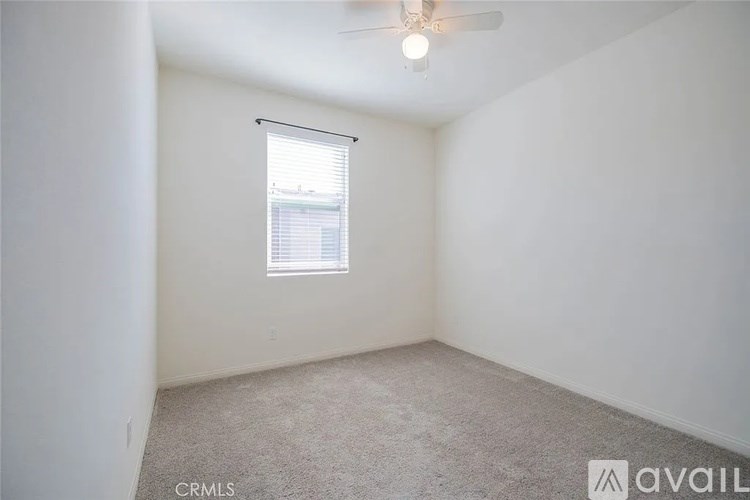 A room with a window and a ceiling fan.