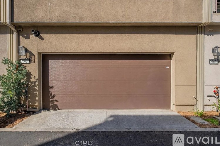 A brown garage door is closed and there is a sign on the wall above it.