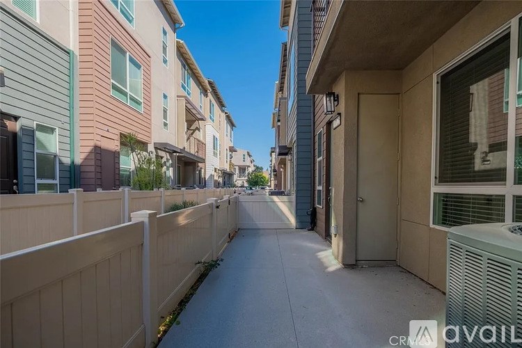 A long, narrow sidewalk runs between two rows of apartment buildings.