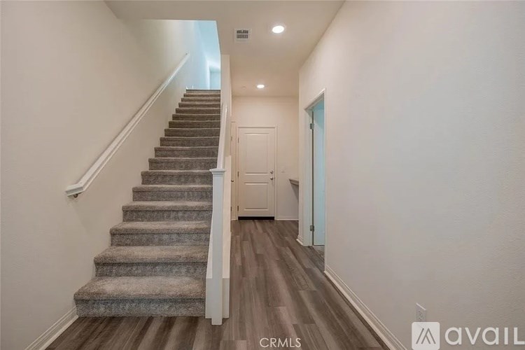 A hallway with a staircase and a door.