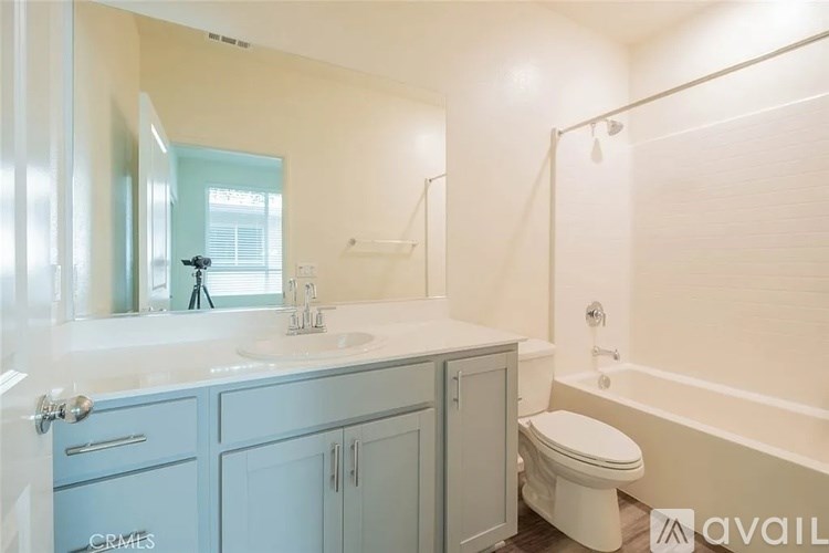 A bathroom with a white tub, sink, and toilet.