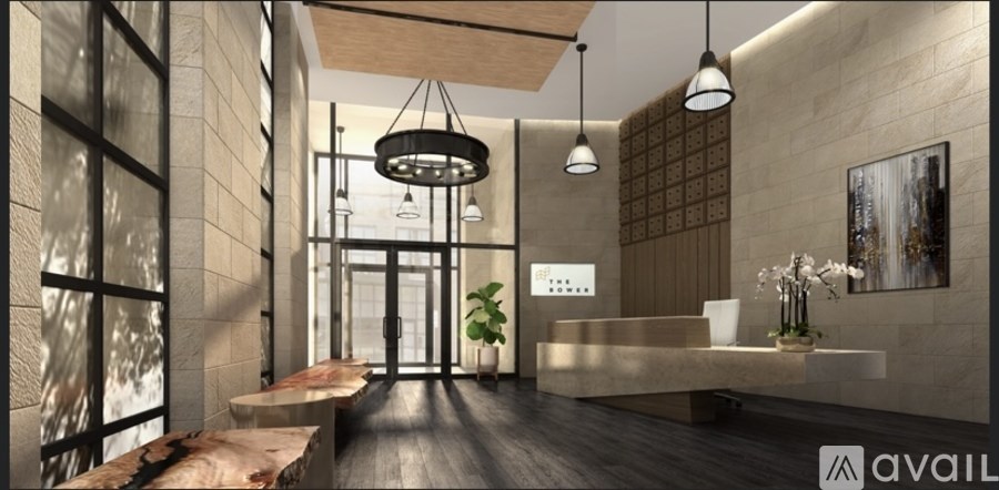 A modern interior space with a long hallway, a reception desk, and hanging light fixtures.