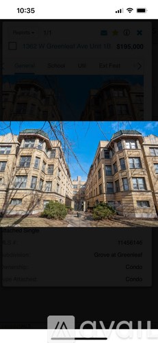 A building with a balcony and a tree in front of it.