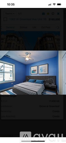 A bedroom with blue walls and a bed with a grey comforter.