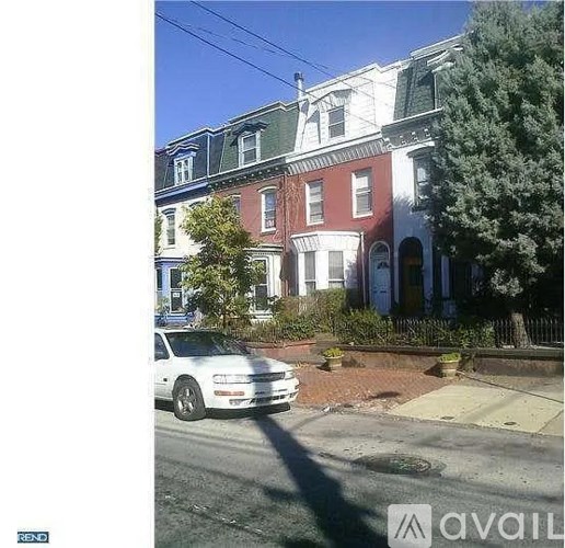 A white car is parked on the side of a street.
