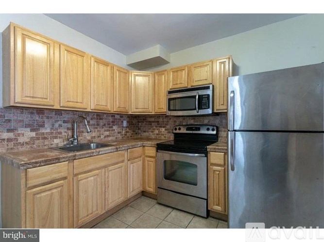 A kitchen with wooden cabinets and stainless steel appliances.