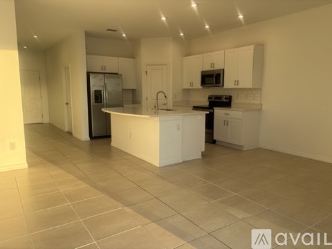 A spacious kitchen with white cabinets and appliances.