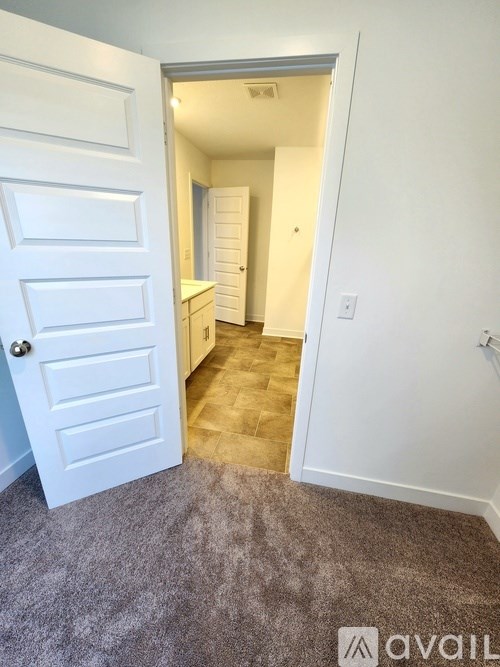A room with a carpeted floor and a white door.