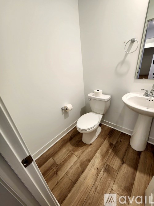 A white toilet and sink in a small bathroom.
