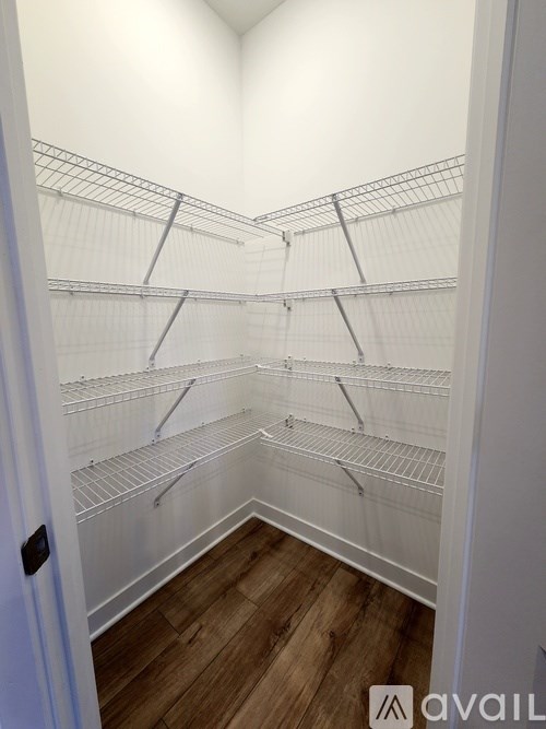 Empty white shelving in a room with wood flooring.