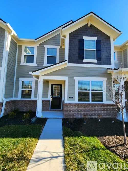 A house with a grey and white exterior and a black door.