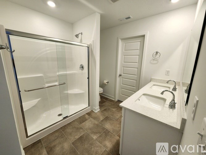 A bathroom with a walk-in shower and double sink vanity.