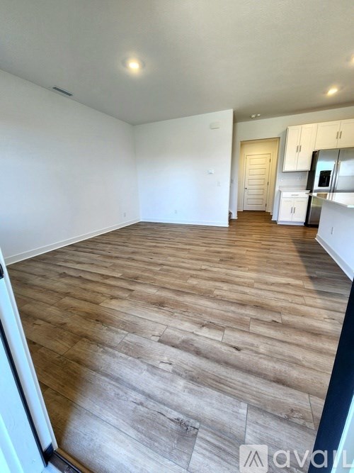A room with wooden flooring and white walls.